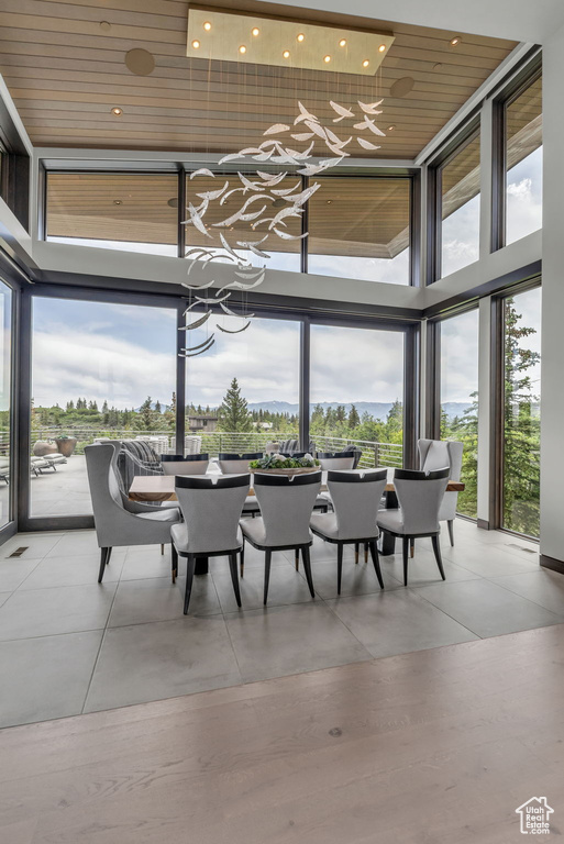 Dining space with a towering ceiling, plenty of natural light, a wall of windows, and recessed lighting