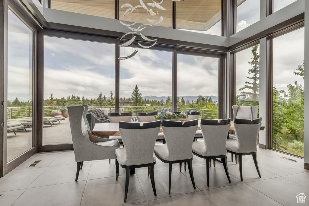 Sunroom / solarium with healthy amount of natural light, a mountain view, and a chandelier