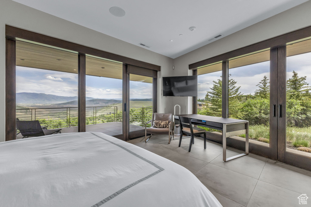 Tiled bedroom featuring access to exterior and multiple windows