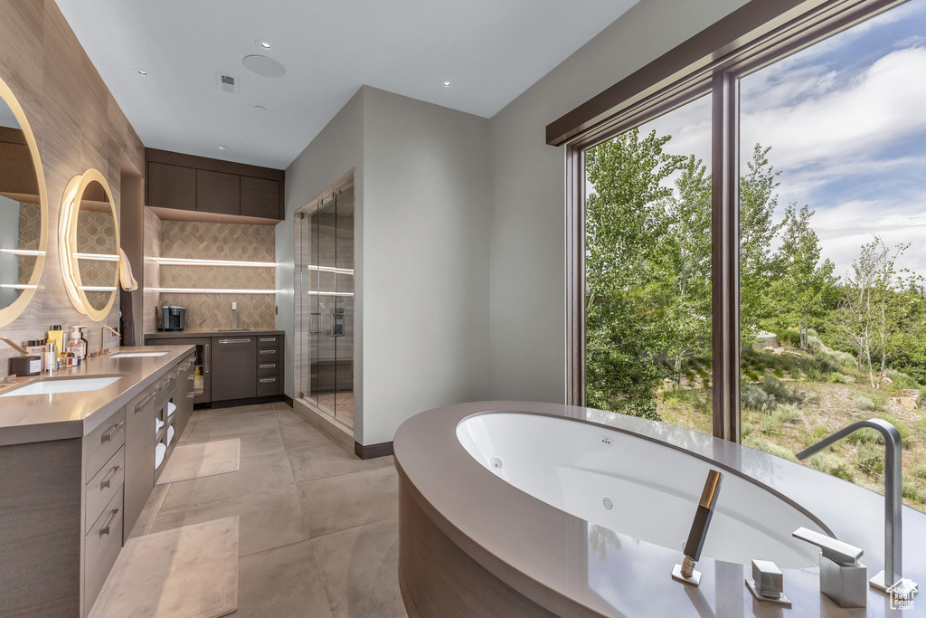 Full bathroom with double vanity, a jetted tub, tasteful backsplash, recessed lighting, and an enclosed shower