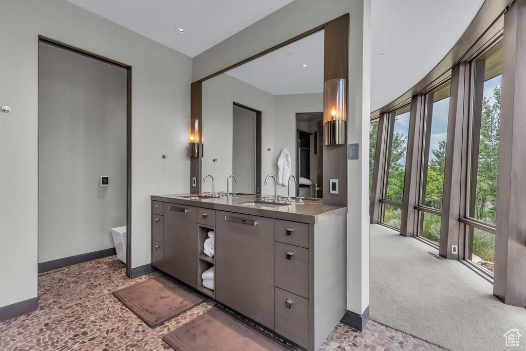 Full bath with double vanity and baseboards