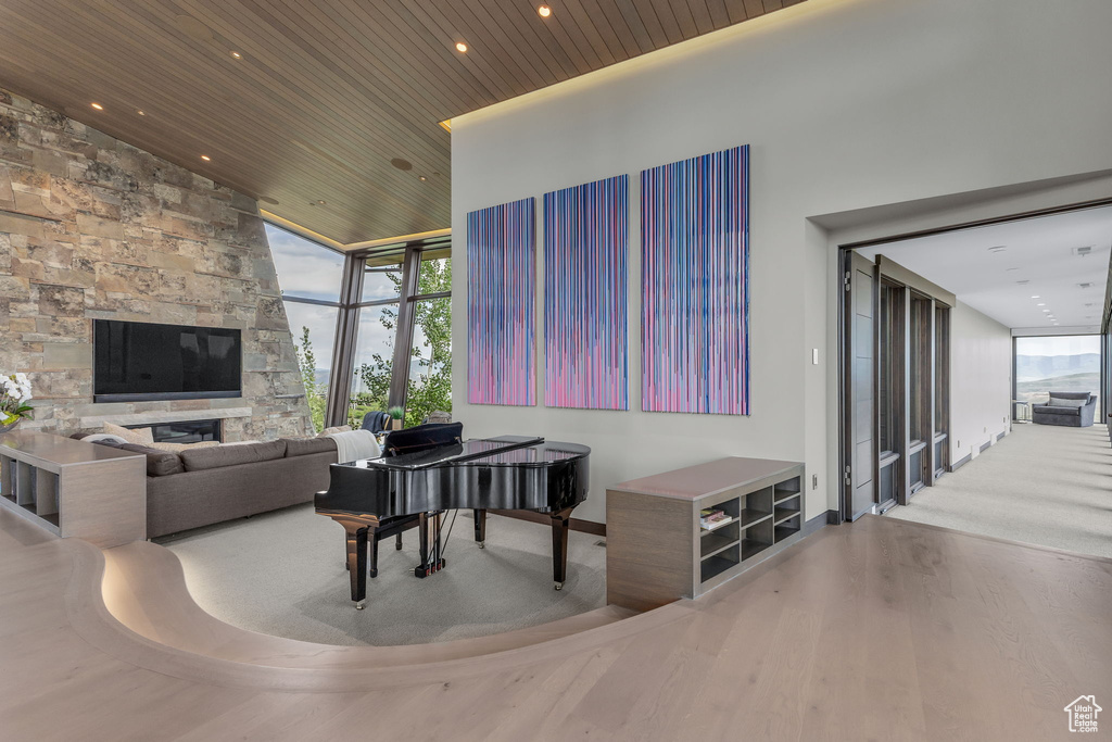 Living area with wooden ceiling, plenty of natural light, wood finished floors, expansive windows, and recessed lighting