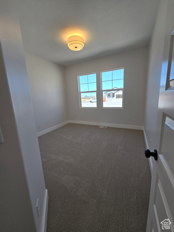 Spare room with carpet, baseboards, and visible vents