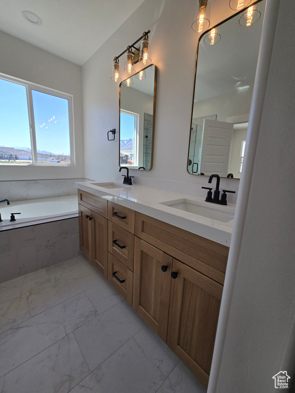 Full bathroom with a sink, double vanity, a bath, and marble finish floor