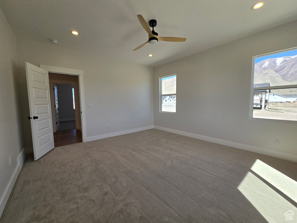 Carpeted spare room featuring visible vents, baseboards, a ceiling fan, and recessed lighting