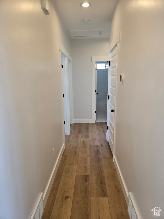 Corridor featuring recessed lighting, hardwood / wood-style floors, visible vents, and attic access