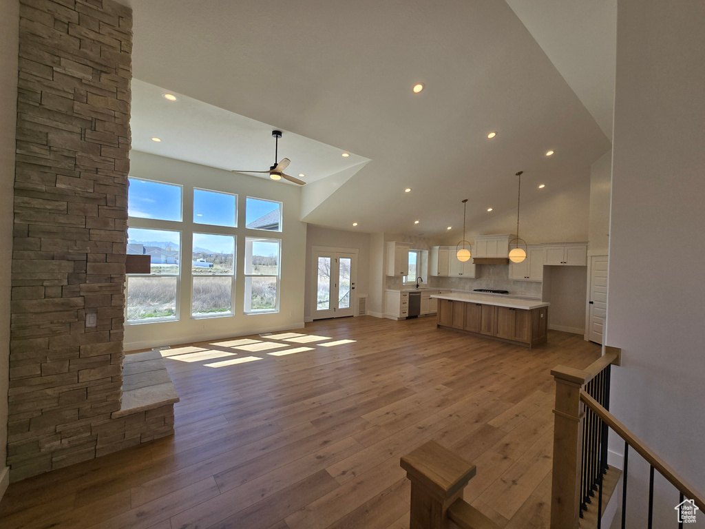 Unfurnished living room with a ceiling fan, light wood-style floors, recessed lighting, and high vaulted ceiling