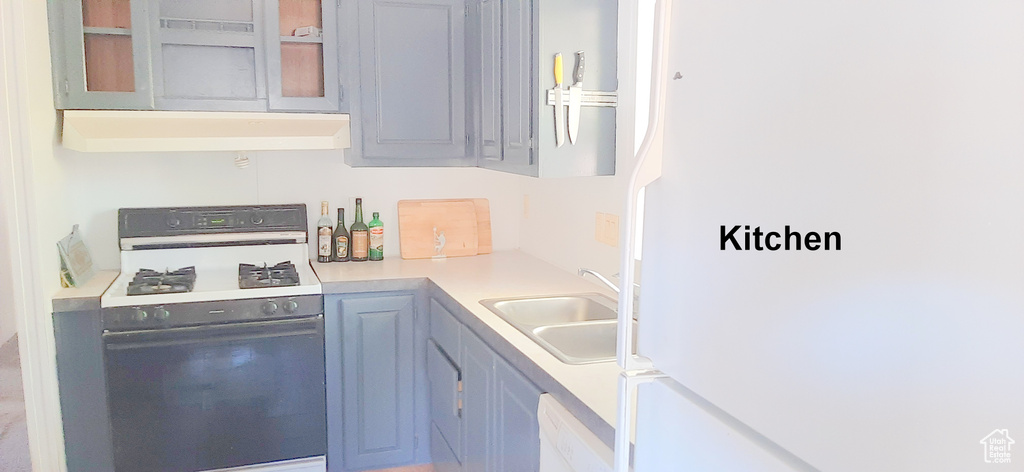 Kitchen with sink, white appliances, and exhaust hood