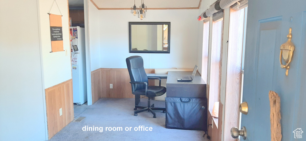 Carpeted office with ornamental molding and wood walls