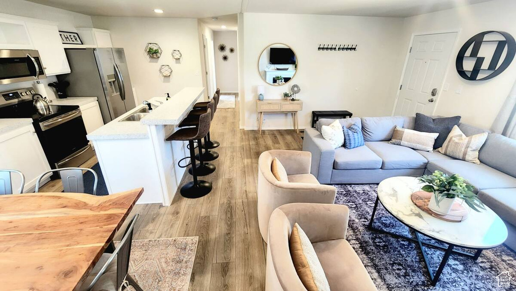 Living room with light wood-type flooring and sink