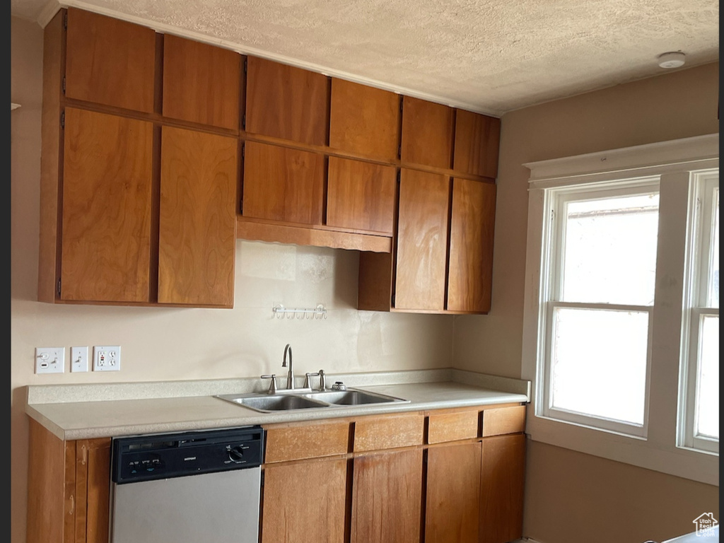 Kitchen with black range with gas stovetop, a textured ceiling, sink, light tile patterned floors, and dishwasher