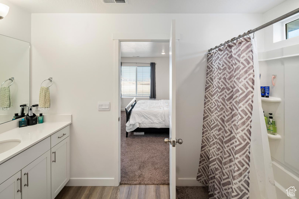 Bathroom with a shower with shower curtain, vanity, and wood-type flooring