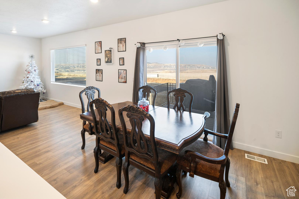 Dining area with hardwood / wood-style floors and a healthy amount of sunlight