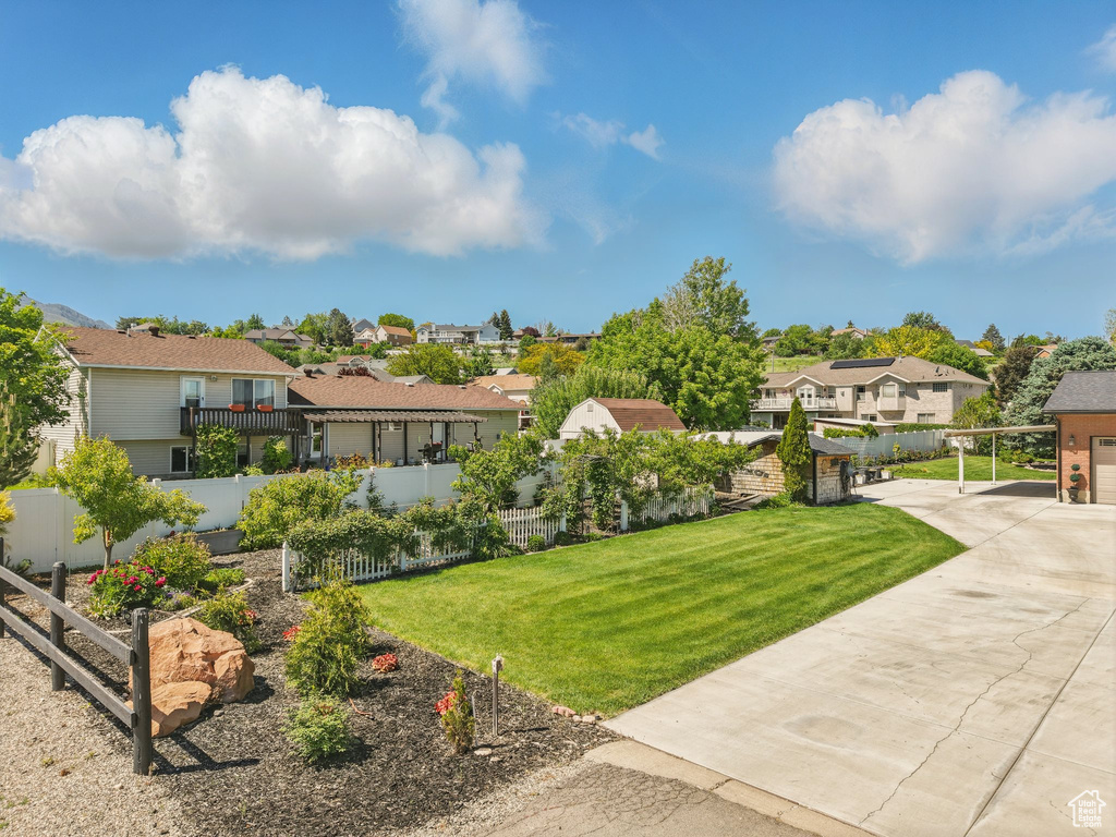 View of yard with a residential view, driveway, and a carport