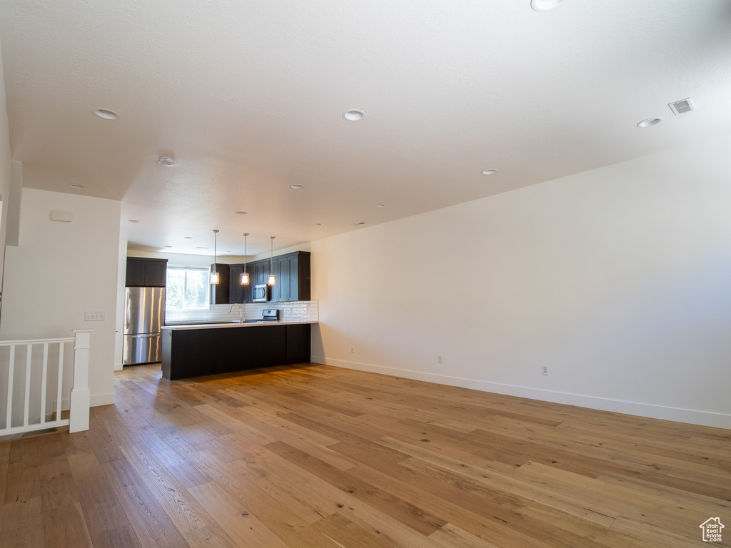 Unfurnished living room featuring light wood-type flooring and recessed lighting