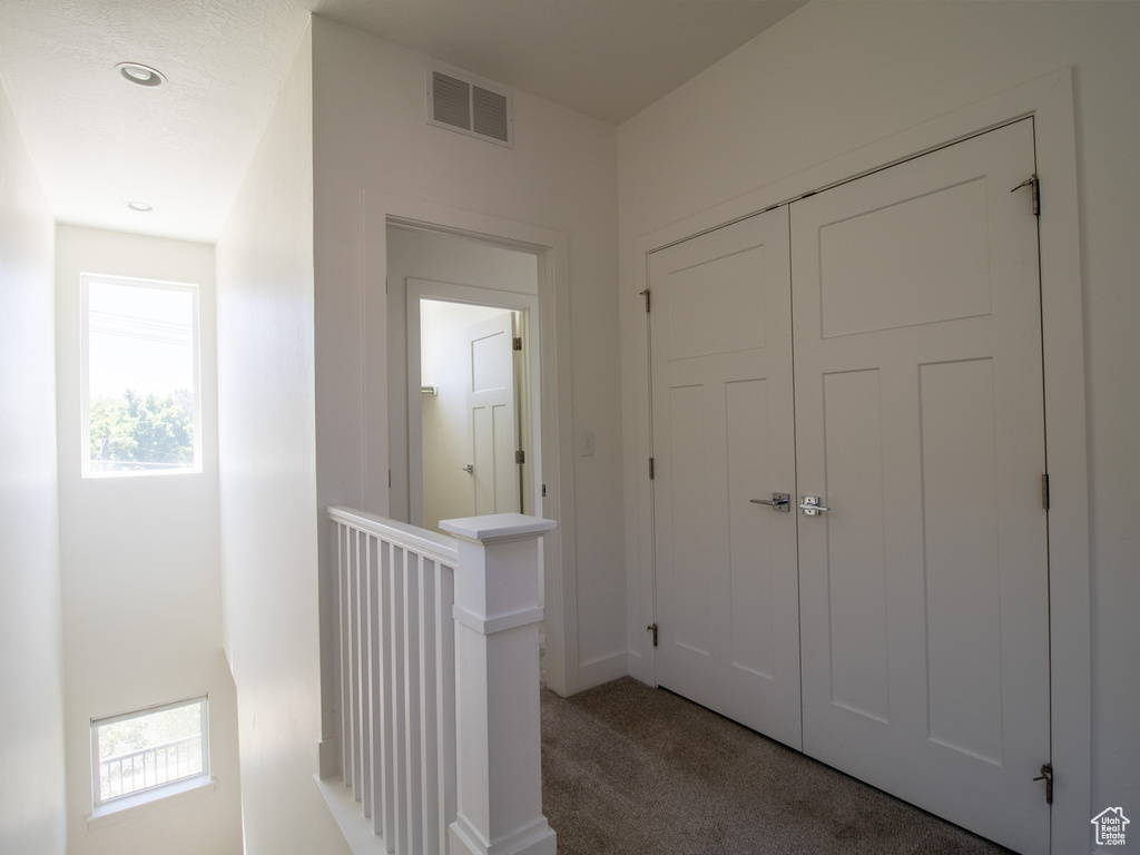 Hall with an upstairs landing, carpet floors, plenty of natural light, and recessed lighting