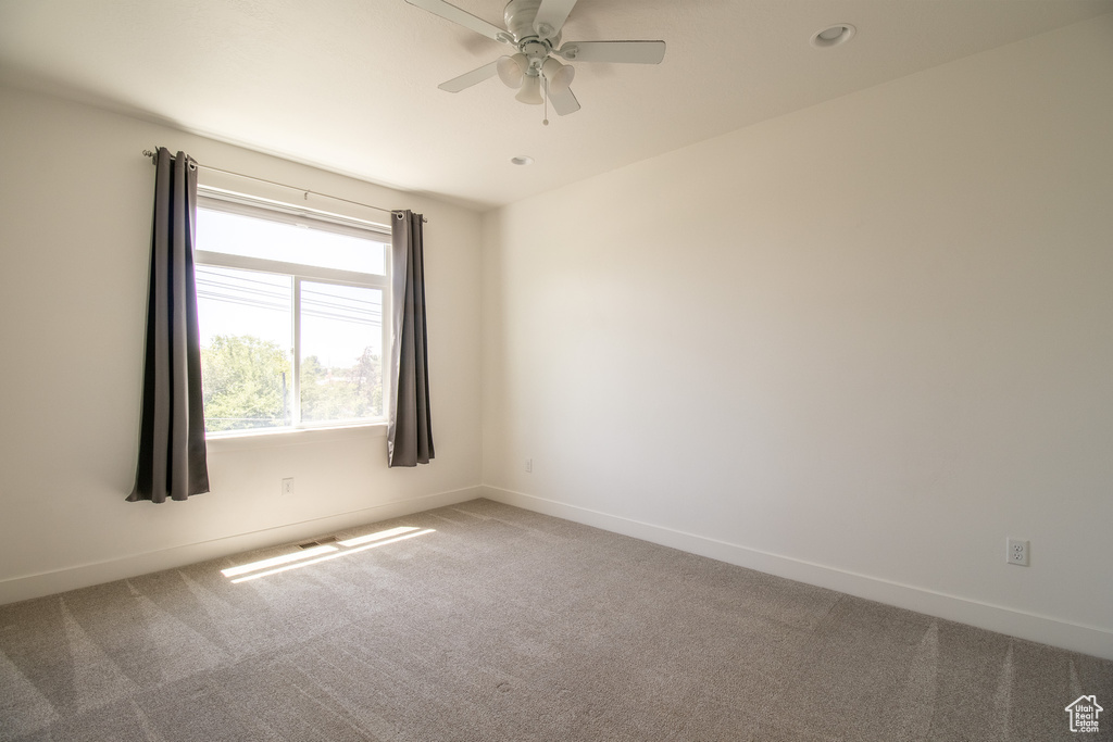 Empty room featuring carpet, ceiling fan, and recessed lighting