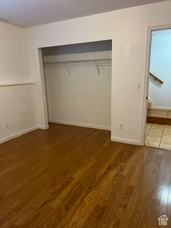 Unfurnished bedroom with hardwood / wood-style flooring and a closet