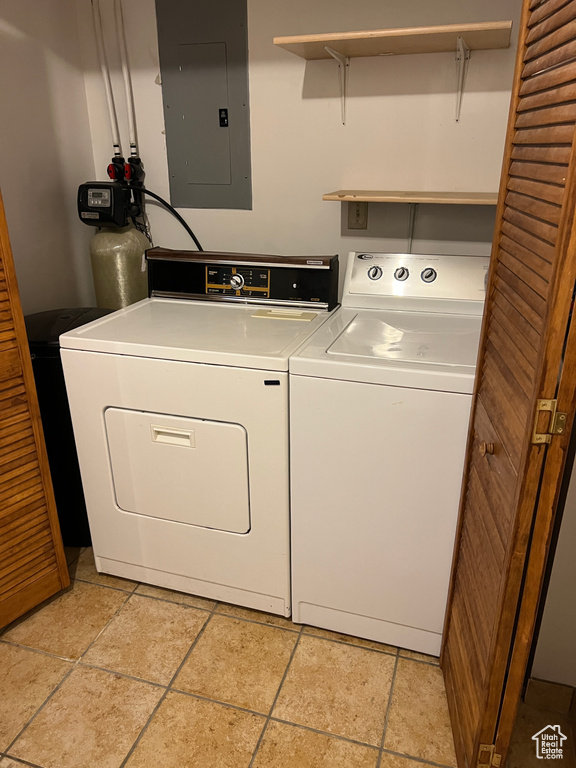 Laundry room featuring electric panel and washer and clothes dryer