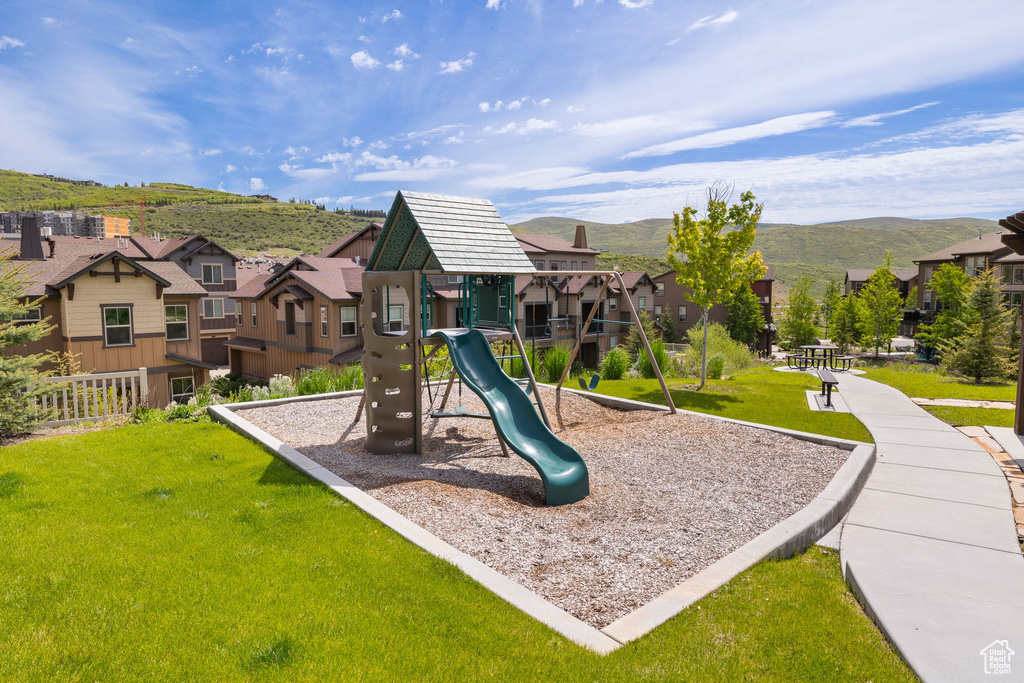 Communal playground with a residential view, a yard, and a mountain view