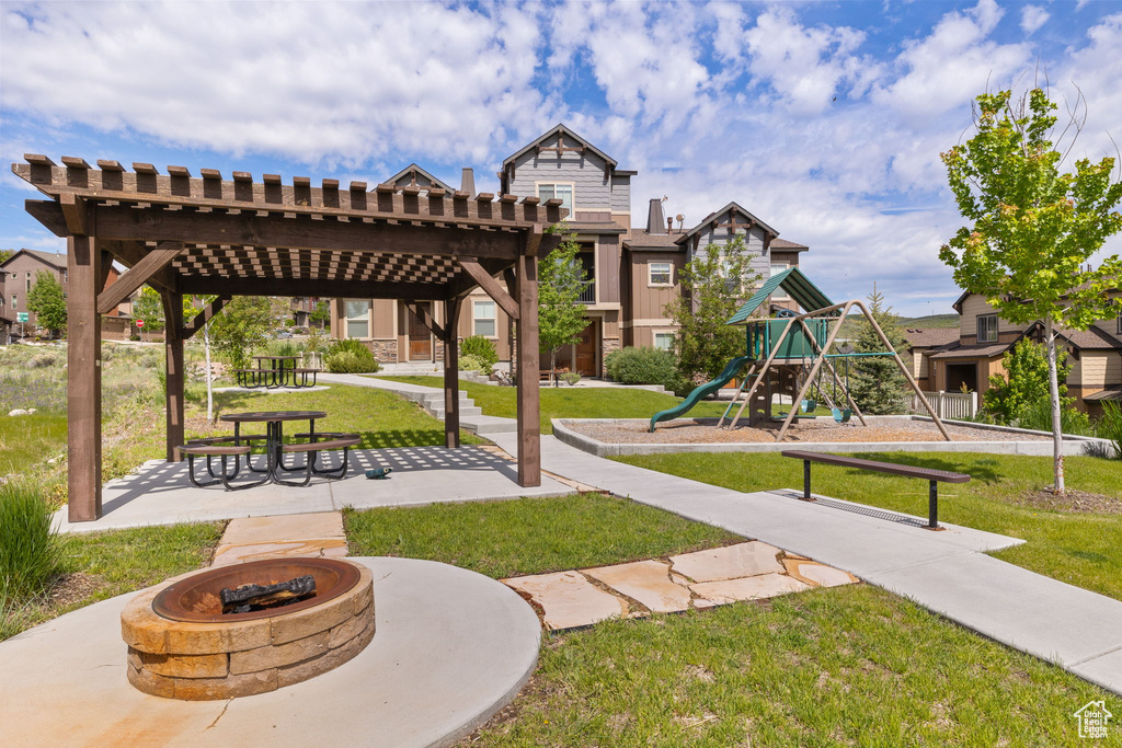 View of property\\\'s community featuring an outdoor fire pit and a yard