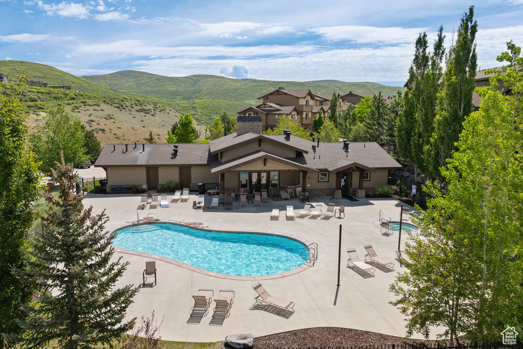 Community pool with a patio area and a mountain view