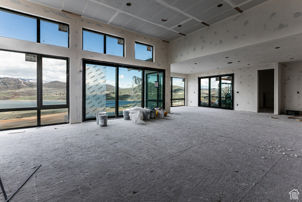 Unfurnished living room with a wealth of natural light and a towering ceiling
