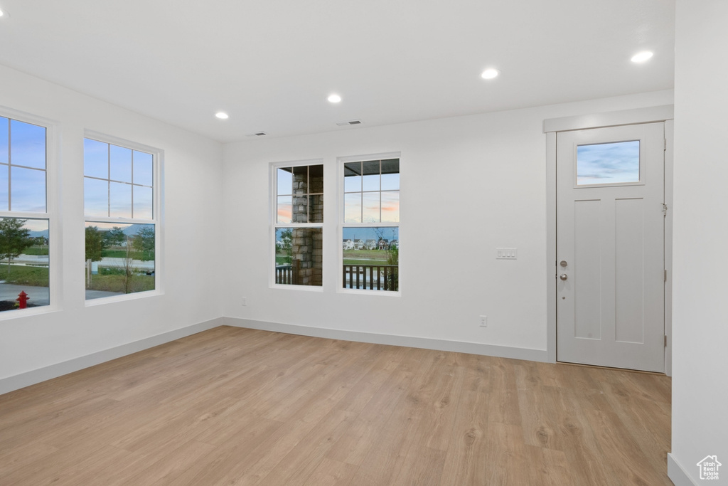 Foyer entrance with light wood finished floors, recessed lighting, and baseboards