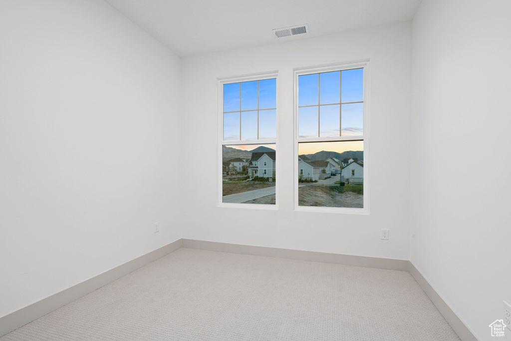 Carpeted empty room featuring baseboards