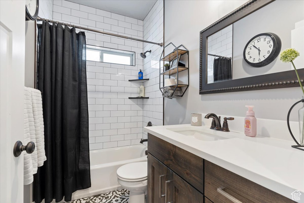 Full bathroom featuring vanity, shower / bathtub combination with curtain, and toilet