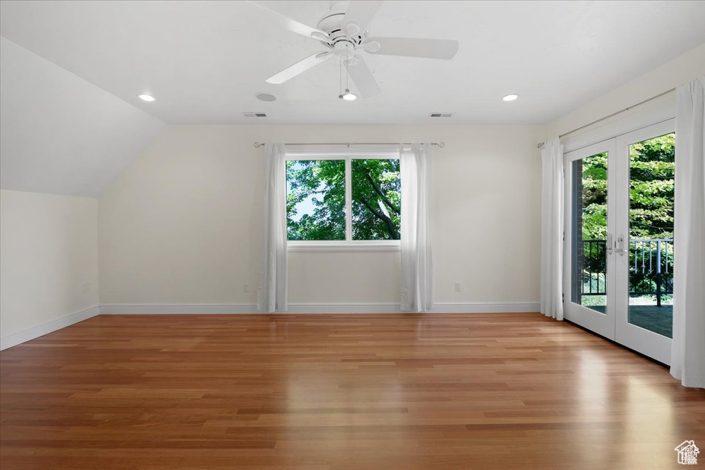 Bonus room with lofted ceiling, french doors, and light hardwood / wood-style flooring