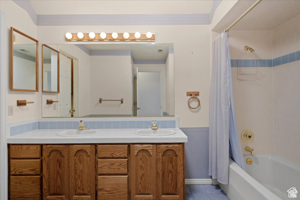 Bathroom with tile patterned floors, vanity, shower / tub combo, and ornamental molding