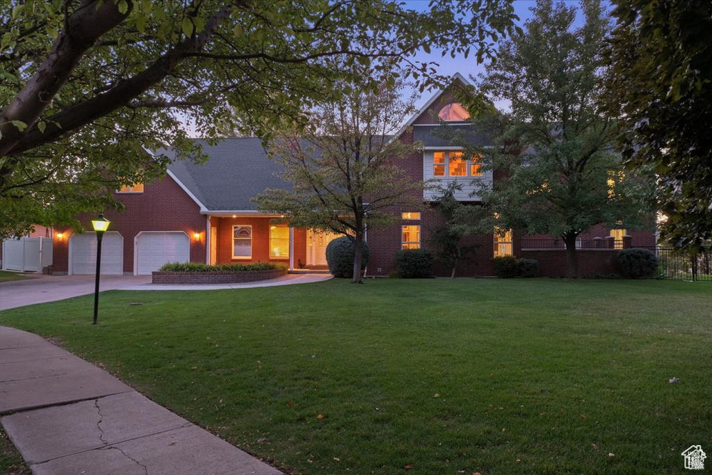 View of front of house with a yard and a garage