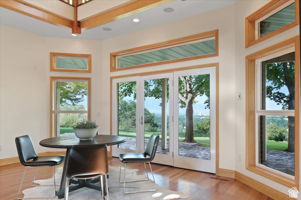 Dining space with plenty of natural light, light hardwood / wood-style floors, and french doors