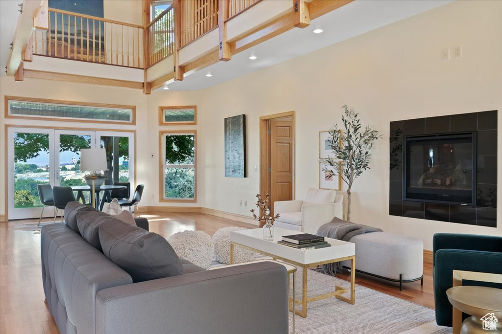 Living room featuring a fireplace, a high ceiling, and light hardwood / wood-style flooring