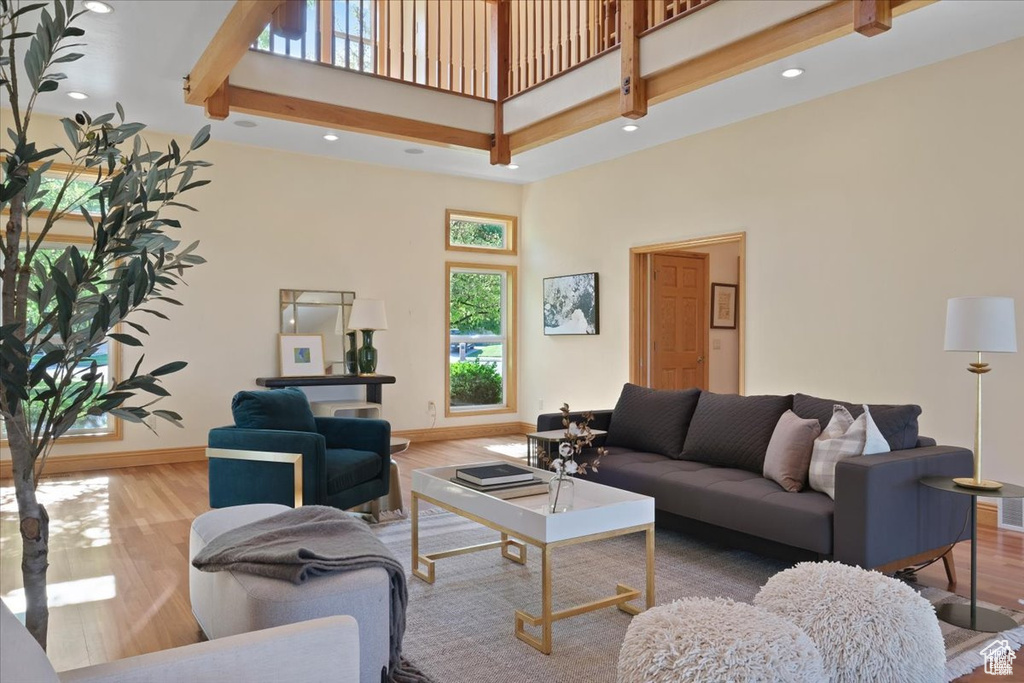 Living room with wood-type flooring and a high ceiling