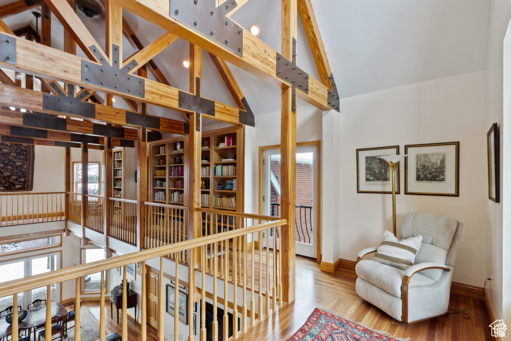 Hall with beamed ceiling, light hardwood / wood-style flooring, and high vaulted ceiling