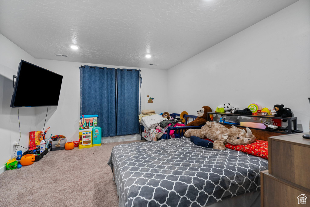 Carpeted bedroom with a textured ceiling