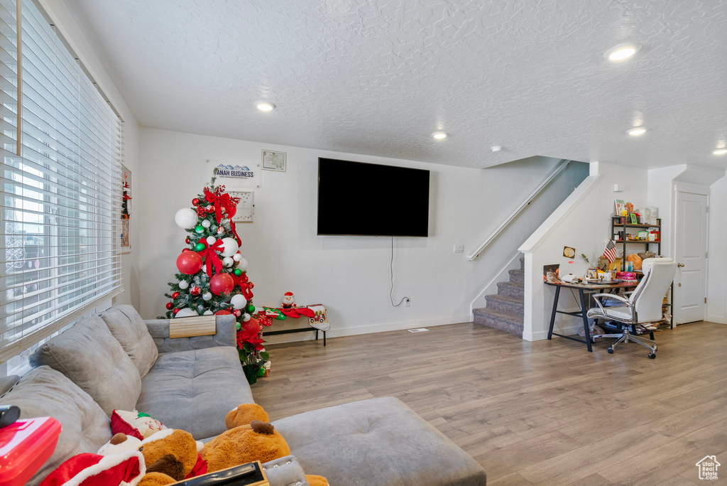 Living room with light wood-type flooring and a textured ceiling