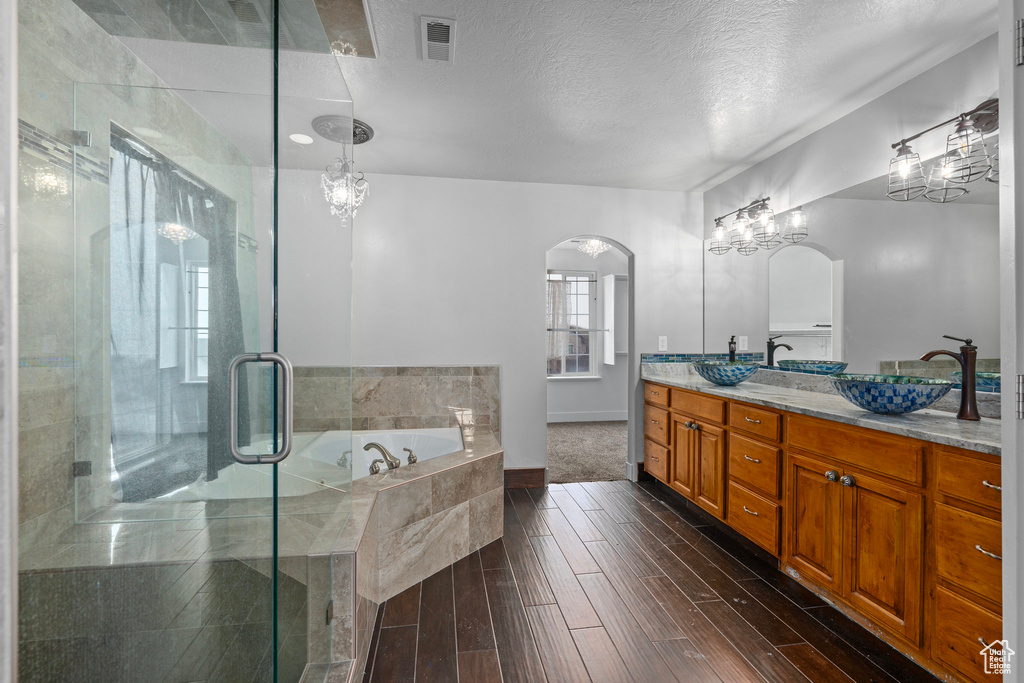 Bathroom featuring separate shower and tub, vanity, a textured ceiling, and hardwood / wood-style flooring