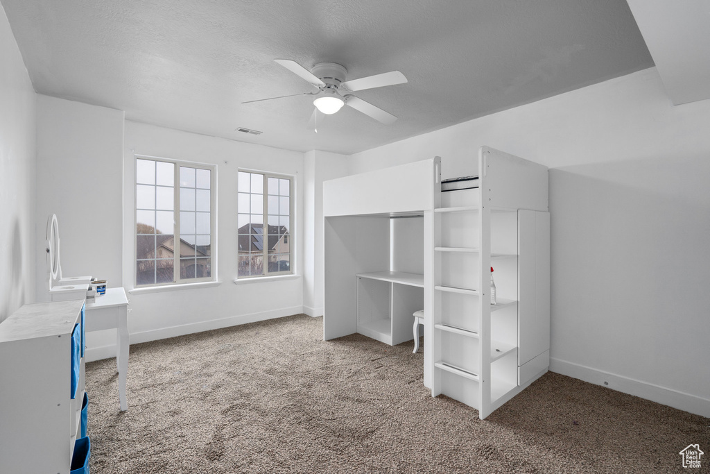 Unfurnished bedroom featuring ceiling fan and carpet floors