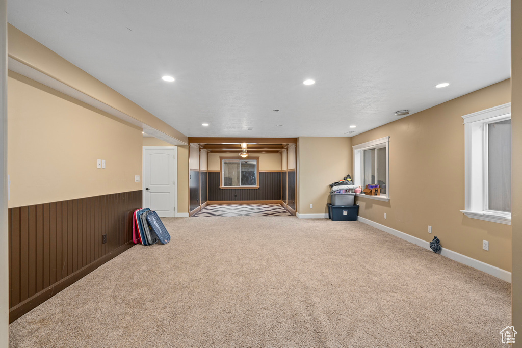 Unfurnished living room with carpet flooring and wooden walls