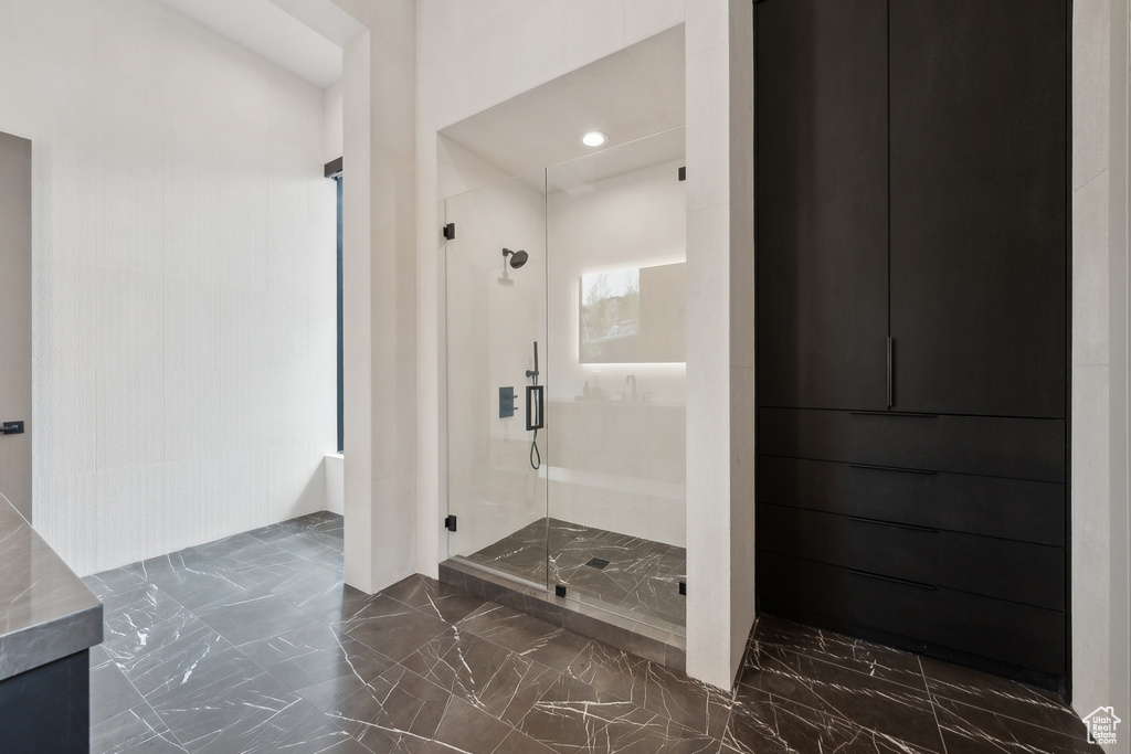 Full bath featuring marble tiled floors, a stall shower, vanity, and recessed lighting