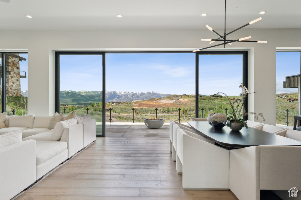 Living room with light wood-type flooring, a mountain view, recessed lighting, and a chandelier