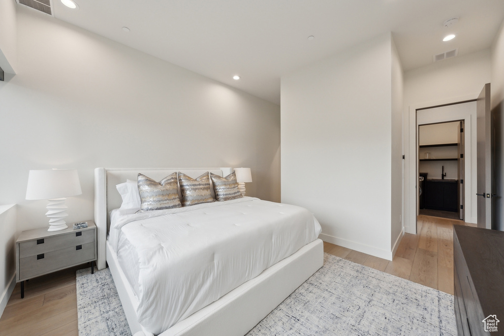Bedroom with light wood-type flooring, baseboards, and recessed lighting