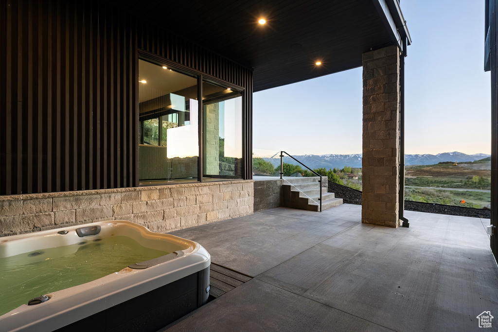 View of patio / terrace featuring a hot tub and a mountain view