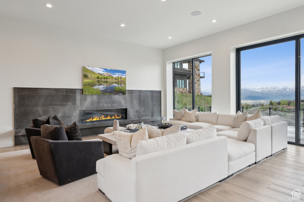 Living area with recessed lighting, a premium fireplace, light wood-style floors, and a mountain view