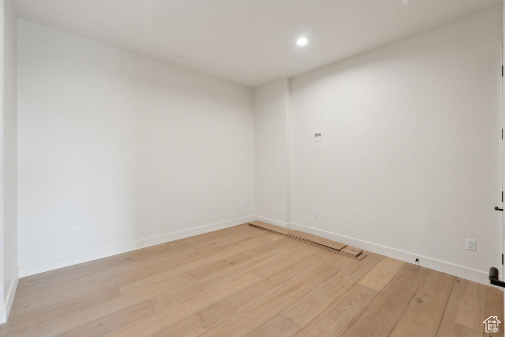 Empty room with light wood-style flooring, baseboards, and recessed lighting