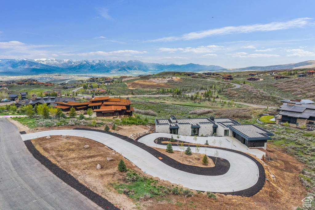 Aerial view of property and surrounding area with a mountain backdrop