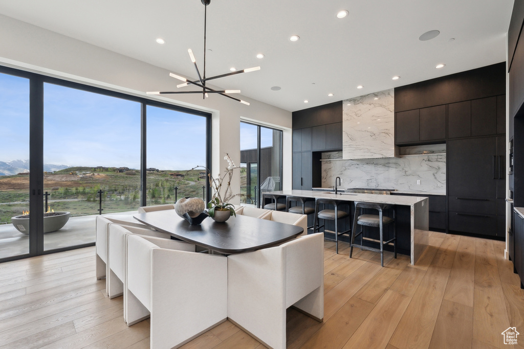 Dining space featuring light wood-style floors, a chandelier, and recessed lighting